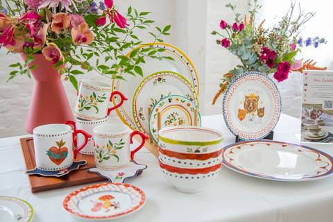 Louças da coleção de Carla Pernambuco e Julia Danesi para Westwing, cuidadosamente dispostas sobre uma mesa, exibindo seus designs e cores no evento de lançamento no Restaurante Carlota em São Paulo.'