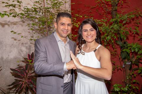 Casal de noivos formando a pose de 'Kinrai' do kung fu, em um gesto simbólico e único que representa sua história, após o casamento no 9º Cartório da Vila Mariana, São Paulo.'