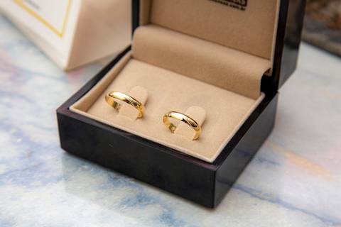 Close-up das alianças de casamento, brilhando e simbolizando a união do casal, em destaque durante a cerimônia no 9º Cartório da Vila Mariana, São Paulo.'