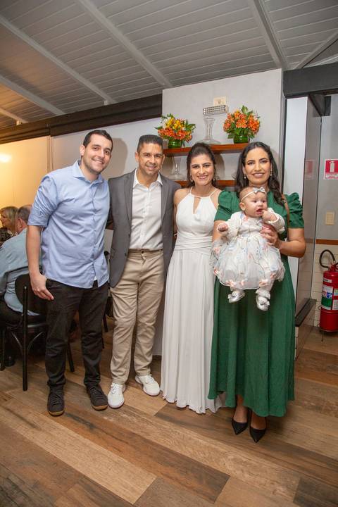 O casal de noivos posando com um grupo de convidados em um registro descontraído na festa de casamento no Restaurante Le Bife em São Paulo.'
