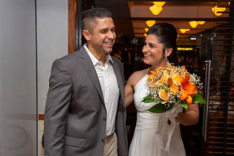 O casal rindo descontraidamente e compartilhando um momento de leveza dentro do Restaurante Le Bife em São Paulo, durante a festa de casamento.'