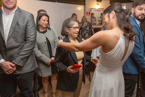 A esposa conversando e rindo com uma convidada, ambas com sorrisos largos, em um momento de cumplicidade na festa de casamento no Restaurante Le Bife em São Paulo.'