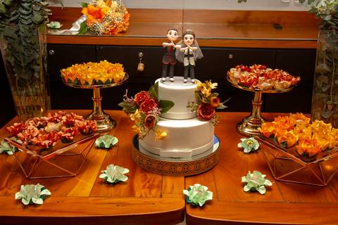 Mesa do bolo decorada no Restaurante Le Bife em São Paulo para a festa de casamento, com doces , criando um ambiente sofisticado.'