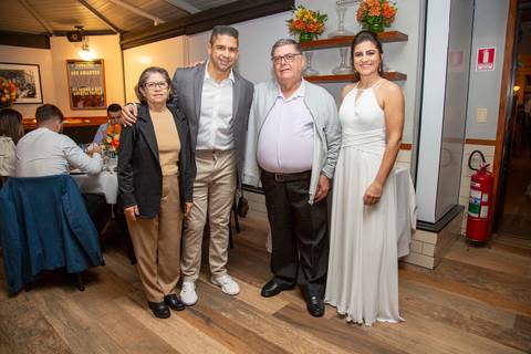 Outra foto posada do casal recém-casado com um grupo de convidados, demonstrando a felicidade e a união do grupo na festa no Restaurante Le Bife em São Paulo.'