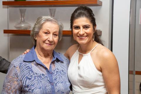A esposa posando para uma foto com uma convidada, ambas sorrindo e compartilhando um momento especial na festa de casamento no Restaurante Le Bife em São Paulo.'