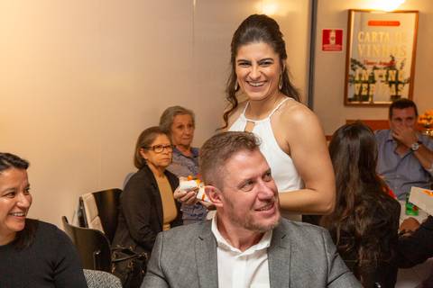 Noiva em destaque, sorrindo radiantemente e interagindo com os convidados, imersa na alegria da festa de casamento no Restaurante Le Bife em São Paulo.'