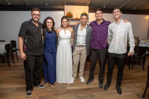 Foto posada do casal recém-casado com um grupo de convidados, todos sorrindo, registrando a alegria compartilhada na festa de casamento no Restaurante Le Bife em São Paulo.'