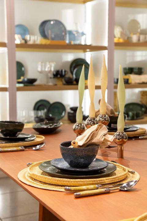 Mesa decorada com velas e arranjos delicados, criando uma atmosfera acolhedora e sofisticada no evento Westwing + Porto Brasil em Moema, São Paulo.'