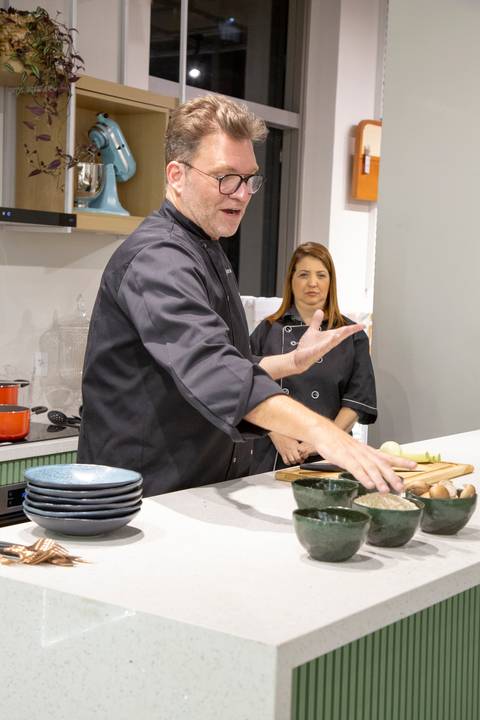 Chef Carlos Bertolazzi explicando detalhadamente os ingredientes do risoto aos participantes do workshop na loja Westwing de Moema, São Paulo.'