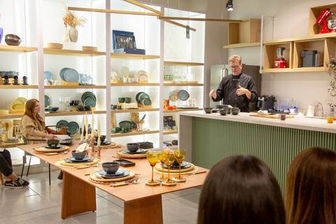 Plano aberto da loja Westwing de Moema, São Paulo, com o Chef Carlos Bertolazzi no centro do espaço do workshop, revelando a grandiosidade do evento.'