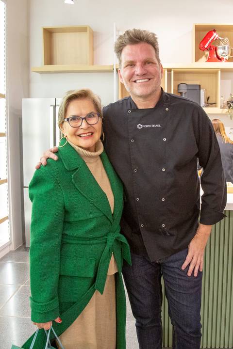 Chef Carlos Bertolazzi posando para uma foto com uma convidada, ambos sorrindo, registrando o encontro no evento Westwing + Porto Brasil em Moema, São Paulo.'