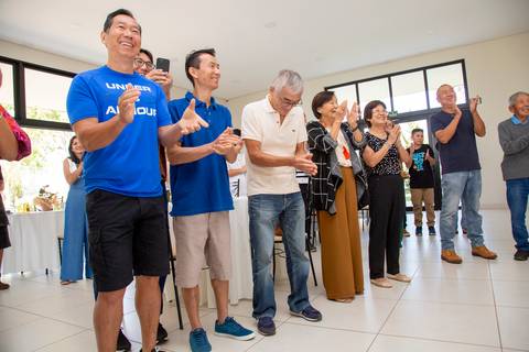 Convidados da festa de 80 anos em Boituva-SP cantando 'Parabéns a Você' com entusiasmo, celebrando a aniversariante ao redor do bolo.'