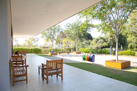 Ampla área externa do local da festa em Boituva-SP, exibindo exuberante vegetação e um belo jardim, perfeito para a celebração do aniversário de 80 anos.'