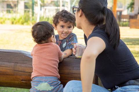 Crianças se divertindo e brincando na área externa da festa em Boituva-SP, sob a supervisão atenta de uma adulta, garantindo a alegria e segurança no aniversário de 80 anos.'