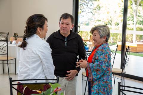 Grupo de convidados do aniversário de 80 anos em Boituva-SP conversando e sorrindo, compartilhando momentos de felicidade e descontração'
