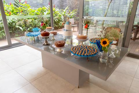 Mesa principal decorada para o chá de bebê em São Paulo, repleta de doces, flores e enfeites que compõem um ambiente festivo e acolhedor.'