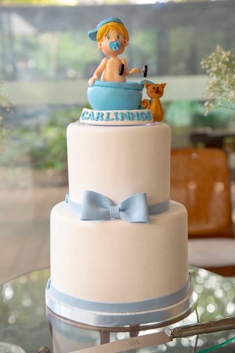 Bolo decorado de chá de bebê com a temática de um menino carregando um peso de academia e um gato laranja ao lado, celebrando a chegada do bebê em São Paulo'