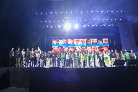 Colaboradores premiados do GPA posando orgulhosamente no palco do Espaço Unimed em São Paulo, exibindo seus prêmios e celebrando o reconhecimento durante o evento.'