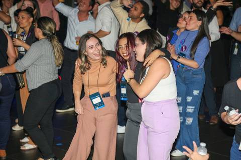 Duas convidadas do Evento GPA conversando e sorrindo na pista de dança do Espaço Unimed em São Paulo, em um momento de interação social e relaxamento.'