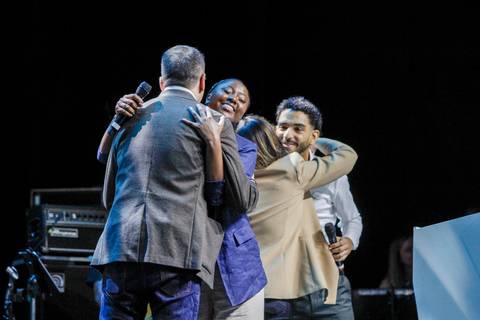 O SEO do GPA e os apresentadores do evento se abraçando no palco do Espaço Unimed em São Paulo, celebrando o sucesso e a união da equipe após as apresentações.'