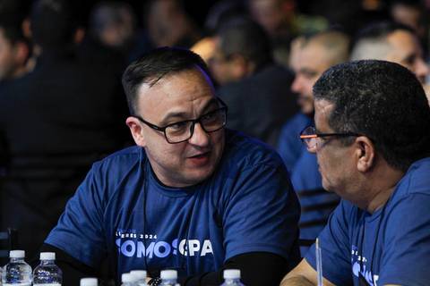 Dois homens no público do Evento GPA no Espaço Unimed em São Paulo, conversando e trocando impressões, em um momento de networking e descontração.'