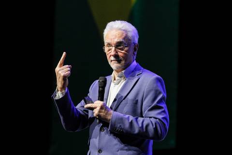 Eugenio Mussak, palestrante convidado, em um momento de fala no palco do Espaço Unimed em São Paulo, com expressão pensativa e engajadora durante o Evento GPA.'