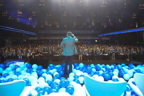 Vista da parte de trás do SEO do GPA no palco do Espaço Unimed em São Paulo, com o vasto público de mais de mil pessoas visível ao fundo, transmitindo a dimensão da audiência e o alcance do evento.'