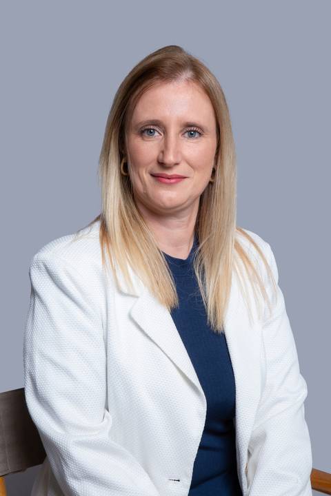 Retrato profissional de mulher loira sentada, olhando diretamente para a câmera com expressão confiante, em ensaio corporativo realizado em São Paulo/SP.'