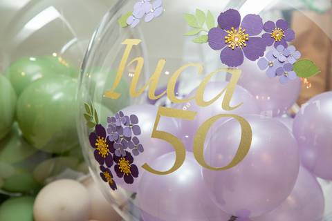 Balão personalizado com o nome da aniversariante de 50 anos, flutuando no espaço decorado do Restaurante Nanako em São Paulo, parte da celebração especial.'