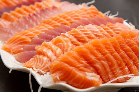 Prato de sashimis frescos e artisticamente dispostos em destaque no buffet do Restaurante Nanako, São Paulo, oferecidos na celebração de aniversário, evidenciando a culinária japonesa.'