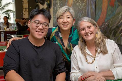 A aniversariante de 50 anos visitando e posando para fotos em diferentes mesas com grupos de convidados, registrando cada momento da celebração no Restaurante Nanako em São Paulo.'