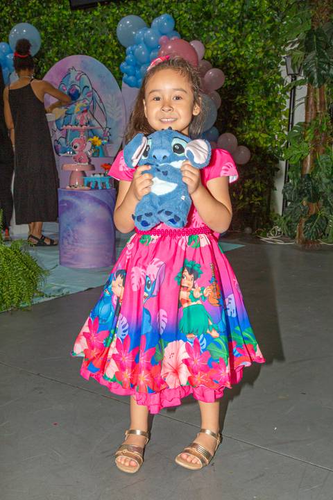 Criança aniversariante segurando o boneco do Stitch na festa temática de Lilo & Stitch no Buffet Vila Terracota, em São Paulo. A imagem transmite afeto, alegria e encantamento infantil.'