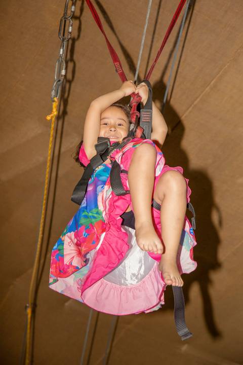 Criança descendo na tirolesa durante a festa infantil com tema Lilo & Stitch no Buffet Vila Terracota, em São Paulo. A imagem captura um momento de diversão, coragem e pura alegria.'