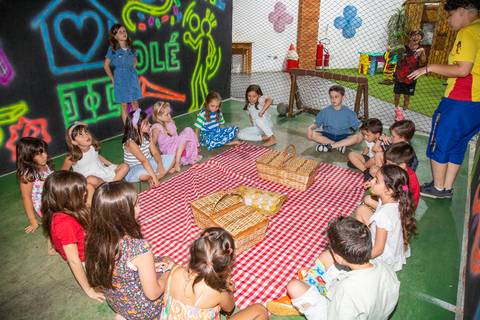 Crianças reunidas fazendo piquenique durante a festa infantil com tema Lilo & Stitch no Buffet Vila Terracota, em São Paulo.'