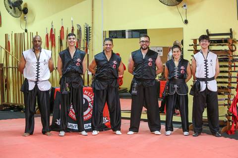 Foto com os mestres faixas pretas da Academia Kwan Kun durante o Exame de Faixa Preta em São Paulo. A imagem transmite respeito, hierarquia e tradição marcial, com destaque para a experiência e liderança dos instrutores que representam os pilares da arte.'