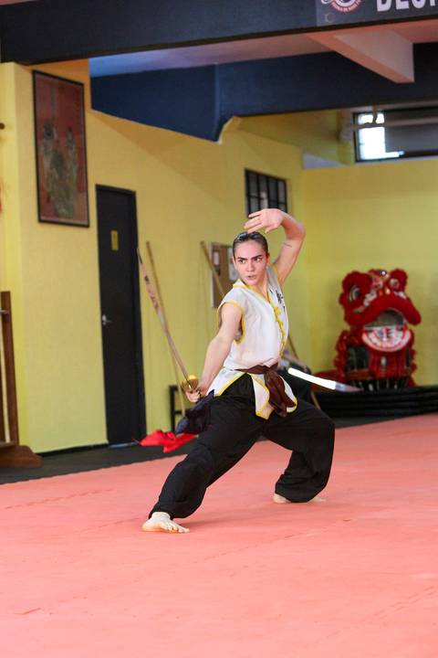 Close de participante do Exame de Faixa Preta na Academia Kwan Kun, em São Paulo, utilizando espada. A imagem destaca concentração, domínio técnico e a tradição das artes marciais.'