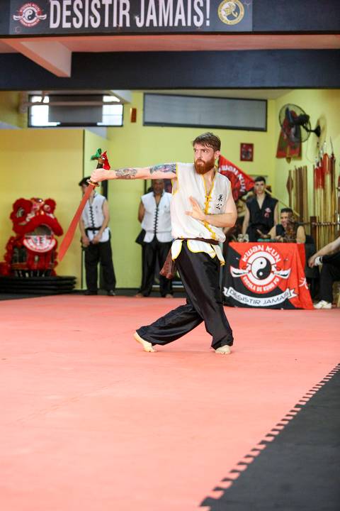 Close de participante do Exame de Faixa Preta na Academia Kwan Kun, em São Paulo, utilizando espada. A imagem destaca concentração, domínio técnico e a tradição das artes marciais.'