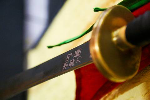 Detalhe da espada tradicional utilizada durante o Exame de Faixa Preta na Academia Kwan Kun, em São Paulo. A imagem destaca a lâmina sob a luz, representando honra, precisão e o espírito das artes marciais, registrada com olhar artístico por Bruno Arita.'