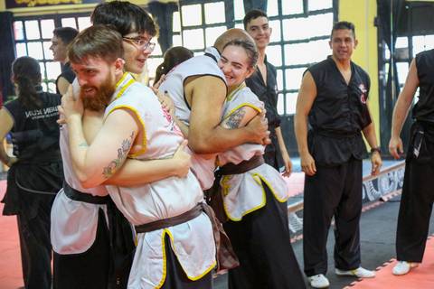 Participantes se abraçam com alegria ao final do Exame de Faixa Preta na Academia Kwan Kun, em São Paulo. A imagem transmite emoção, conquista e o espírito de união nas artes marciais.'