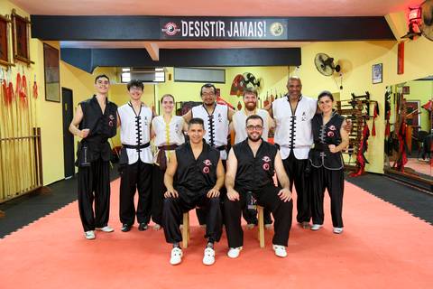 Participantes posam para foto com o mestre e os faixas pretas ao final do Exame de Faixa Preta na Academia Kwan Kun, em São Paulo. A imagem celebra conquista, respeito e tradição marcial.'