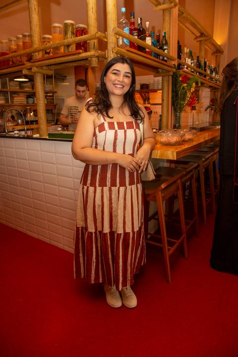 Participante do evento Westwing no Clandestina Restaurante em São Paulo, sorrindo e interagindo no ambiente sofisticado, refletindo o engajamento e a experiência exclusiva para influenciadores digitais.'