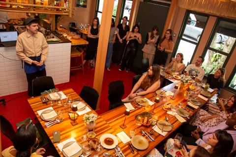 Vista superior do evento Westwing no Clandestina Restaurante em São Paulo, revelando a organização do espaço, mesas decoradas, e a movimentação dos influenciadores digitais em um ambiente elegante e integrado.'