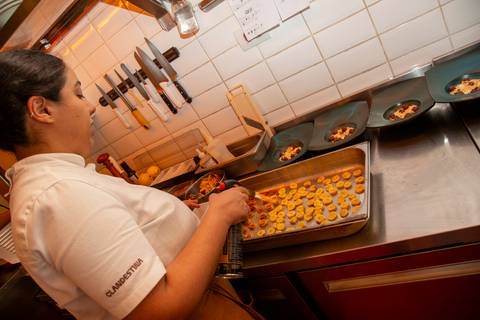 Chef do Clandestina Restaurante em São Paulo preparando uma sobremesa sofisticada durante o evento Westwing com influenciadores digitais, destacando a experiência gastronômica e o cuidado com os detalhes culinários.'