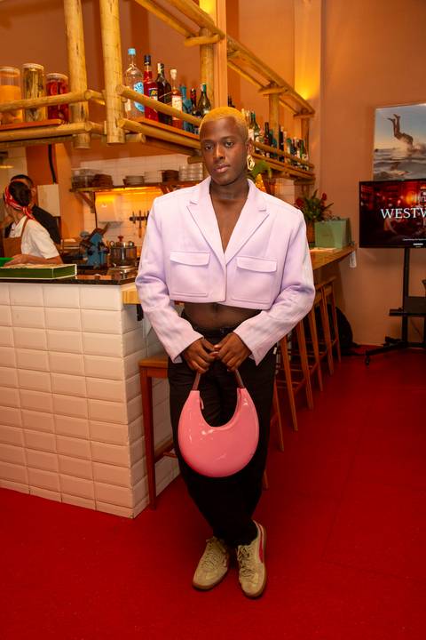 Participante do evento Westwing no Clandestina Restaurante em São Paulo, sorrindo e interagindo no ambiente sofisticado, refletindo o engajamento e a experiência exclusiva para influenciadores digitais.'