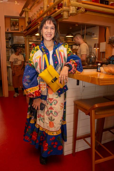 Participante do evento Westwing no Clandestina Restaurante em São Paulo, sorrindo e interagindo no ambiente sofisticado, refletindo o engajamento e a experiência exclusiva para influenciadores digitais.'