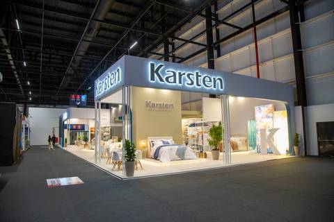 Estande da Karsten na ABUP Show 2025 no Distrito Anhembi, visto de fora, exibindo o design convidativo e a identidade visual da marca no evento'