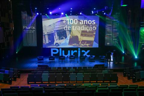Interior do Teatro B32 em São Paulo, elegantemente decorado e vazio antes do início do evento corporativo da Plurix, com palco e assentos prontos para os participantes'