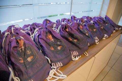 Lembrancinha da festa de 5 anos com tema Wandinha no Buffet Vip Kids: uma sacolinha de alça com a foto da Wandinha e o nome da aniversariante.'