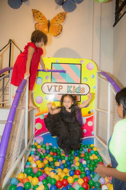 Aniversariante caindo em um brinquedo de arremesso de bolinhas em sua festa no Buffet Vip Kids em São Paulo, em um momento divertido e espontâneo.'