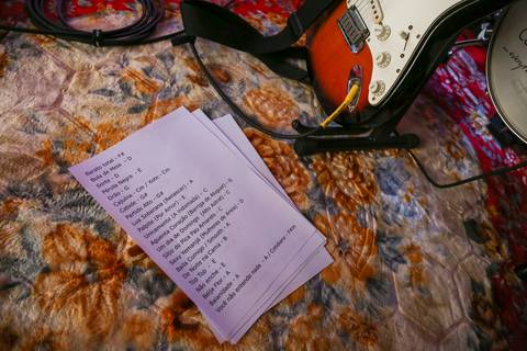 Setlist da banda Madressilva sobre um tapete no chão, com uma guitarra visível ao fundo, pronto para a apresentação. (reFestança, São Paulo) fotografia Bruno Arita'